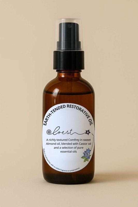 Crest Earth-Tended Restorative Oil in amber glass pump bottle – comfrey infused with sweet almond and castor oil blended with pure essential oils.